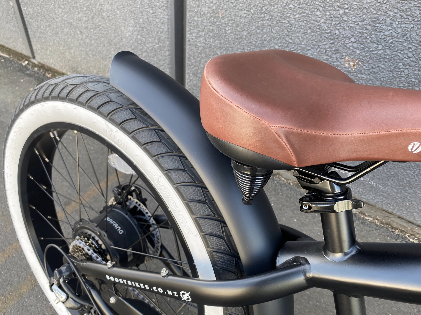 The Scout Electric Motorbike from Boostbikes. Classic Black and Tan detailing, matt black frame with tan vegan leather seat, tank and grips with Kenda All Terrain tyres. 