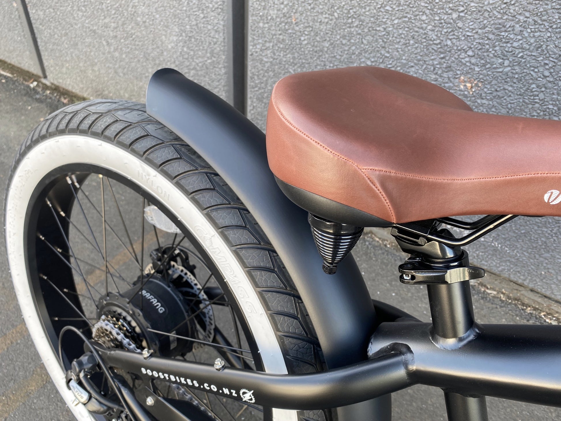 The Scout Electric Motorbike from Boostbikes. Classic Black and Tan detailing, matt black frame with tan vegan leather seat, tank and grips with Kenda All Terrain tyres. 